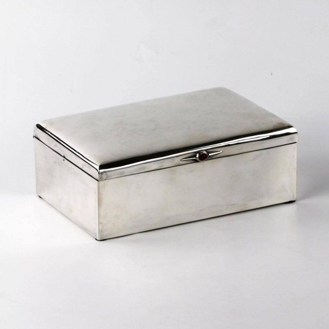 Silver cigar box: A laconic cigar box of 830 Swedish silver. A piece of elegant simplicity with a red cabochon on the snap. The interior is finished with cherry wood. The button is inlaid with a semi-precious stone, ca