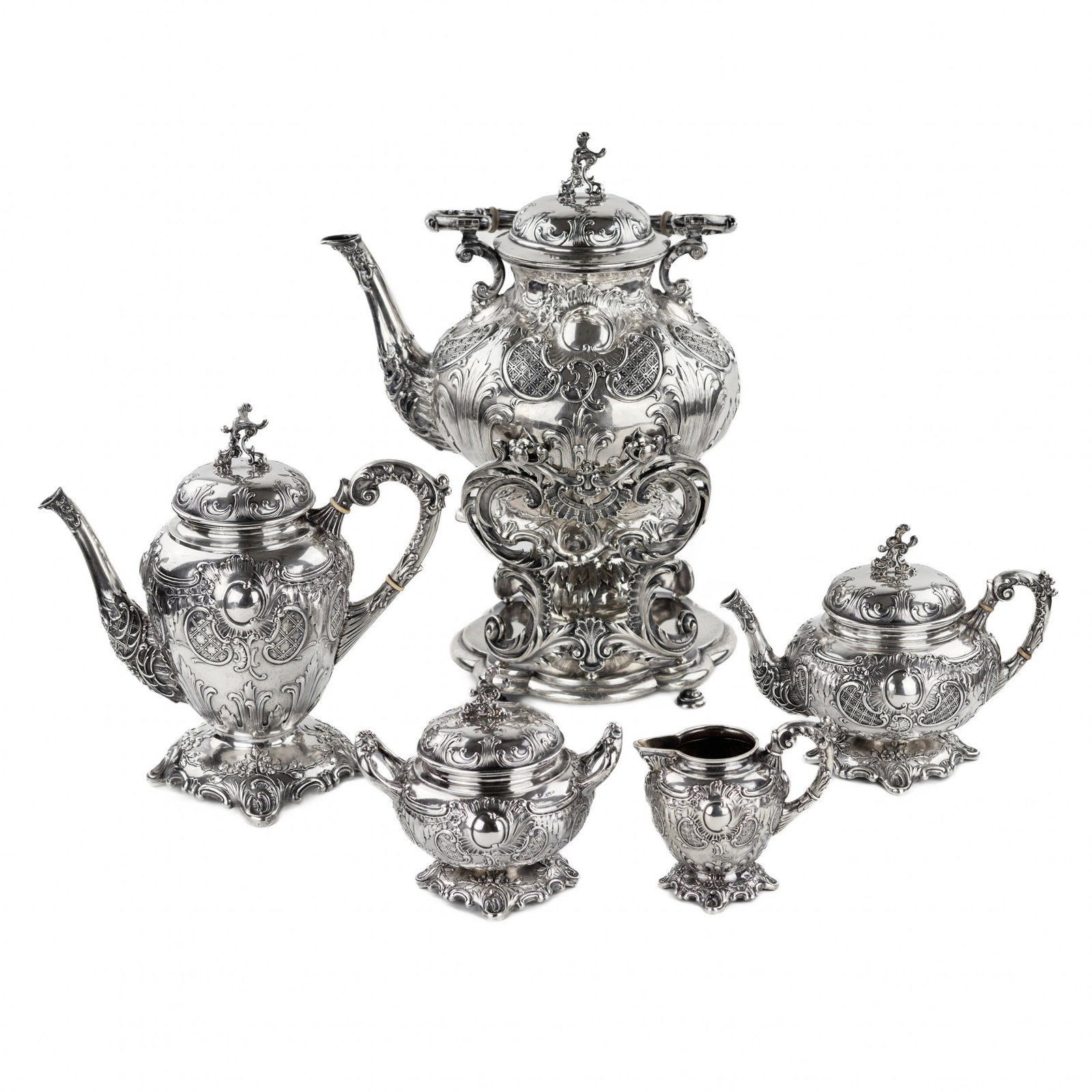 Complete, silver tea and coffee service. Poland. 1900: Complete tea and coffee service in 84 sterling silver. Comprising: teapot, coffee pot, sugar bowl, milk jug and bouillotte, with stand and burner. With playful rococo embossing, each piece rests on sq