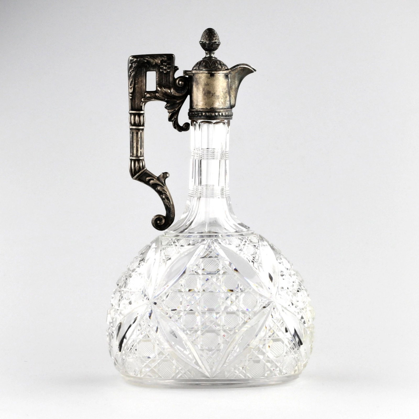 Russian liqueur decanter, crystal in silver. Moscow 1907-1913: Heavy crystal liqueur decanter in silver. Combines a crystalline, radiant pattern of cut crystal and a classic pseudo-Renaissance silver finial. Overall, it refers to the images of Italian jugs of the