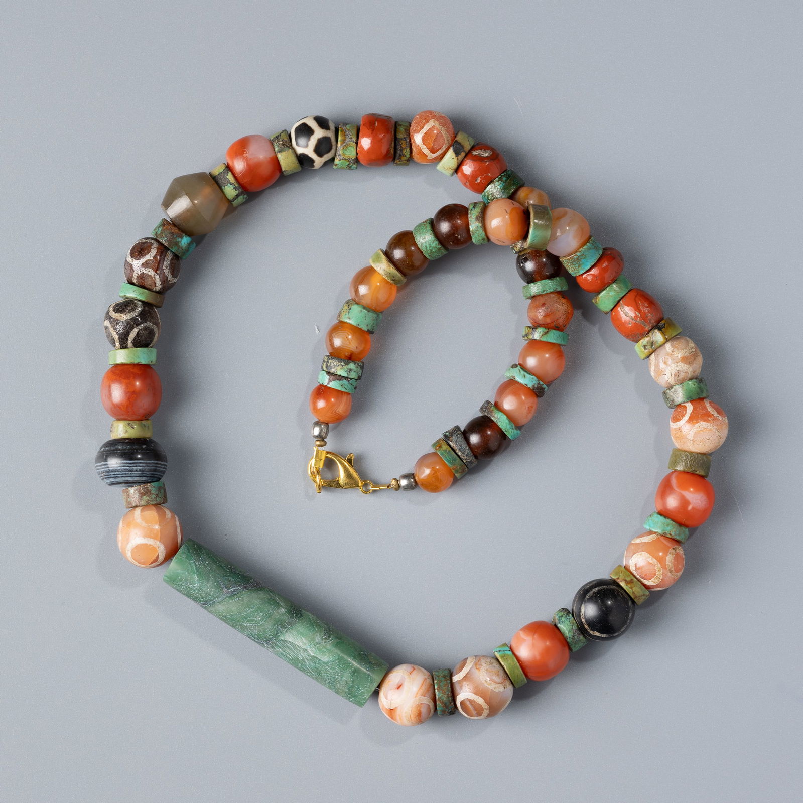 Antique Tibetan Necklace with Carnelian, Amber, Turquoise, Dzi Agate Beads & Central Aventurine Jade: A beautiful antique Tibetan necklace featuring a rich mix of carnelian, amber, turquoise, and dzi agate beads. The centerpiece is a striking long aventurine jade bead.Length: 22 inchesWeight: 111 gram