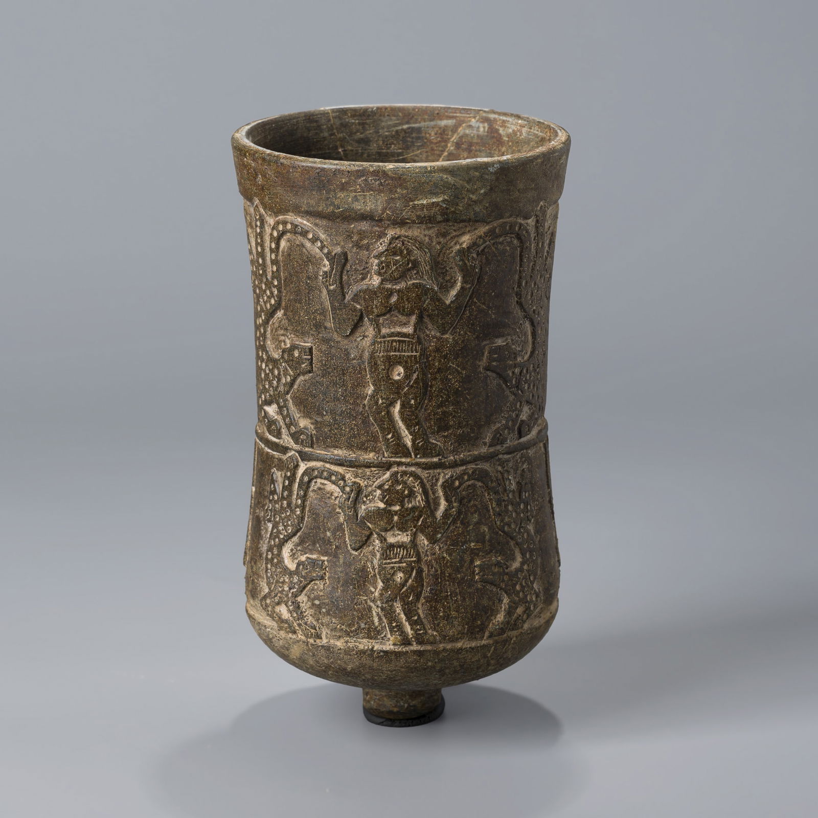 Ancient Near Eastern Carved Stone Ritual Vessel with Figural Reliefs: A carved stone ritual vessel from the ancient Near East, adorned with figural reliefs.Dimensions: 11 x 19.5 cmWeight: 1.5 kg