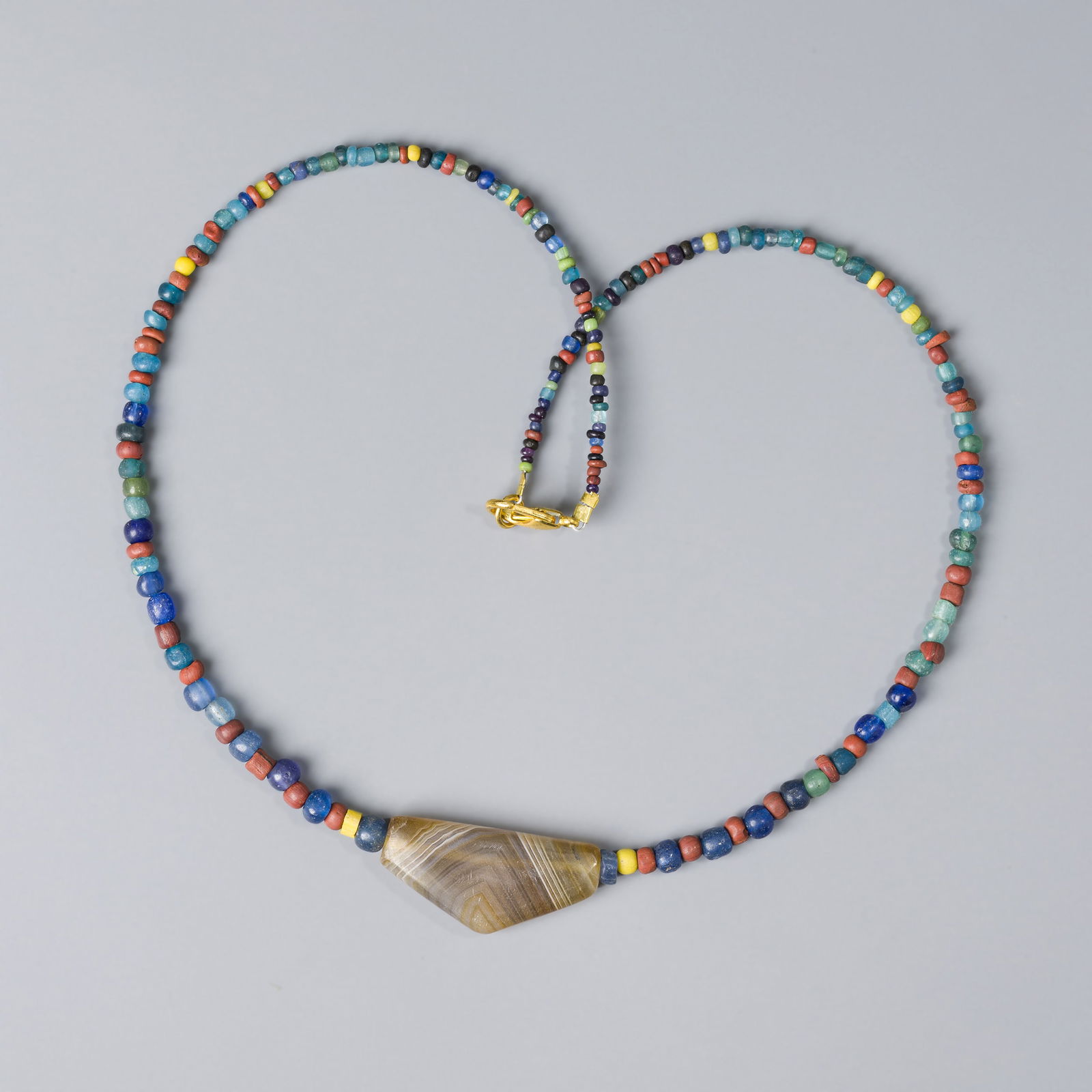 Sino-Tibetan Antique Glass Beads Necklace Featuring Agate Pendant: A 19.5-inch ancient Sino-Tibetan necklace featuring old glass beads and a striking agate bead pendant. Length:19.5in Total Weight : 18gram
