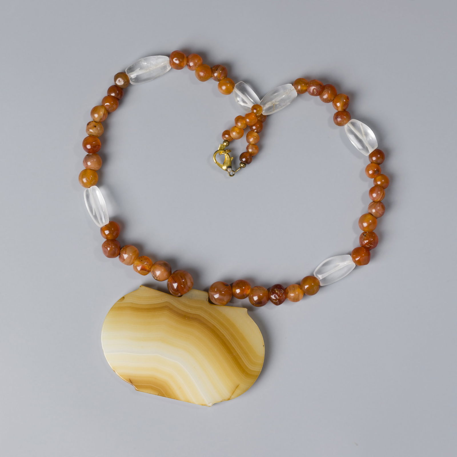 Antique Necklace with Rare Banded Agate Pendant and Carnelian Crystal Beads: This necklace showcases a rare-shaped antique banded agate pendant paired with vintage carnelian and crystal beads. Length:16.5in Total Weight : 92gram