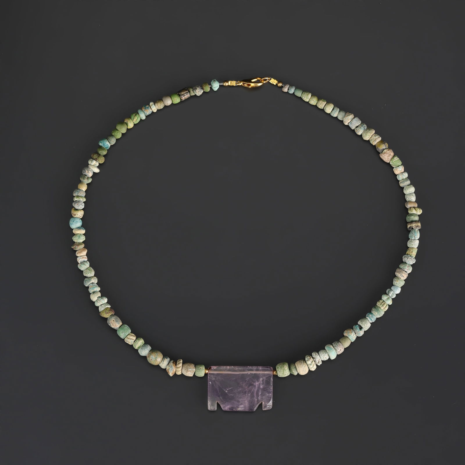 Ancient Roman–Egyptian Faience Glass Beads Necklace with Central Amethyst Pendant: A necklace composed of ancient Roman–Egyptian faience glass beads, featuring a central amethyst pendant. Length: 21in Total Weight: 39gram