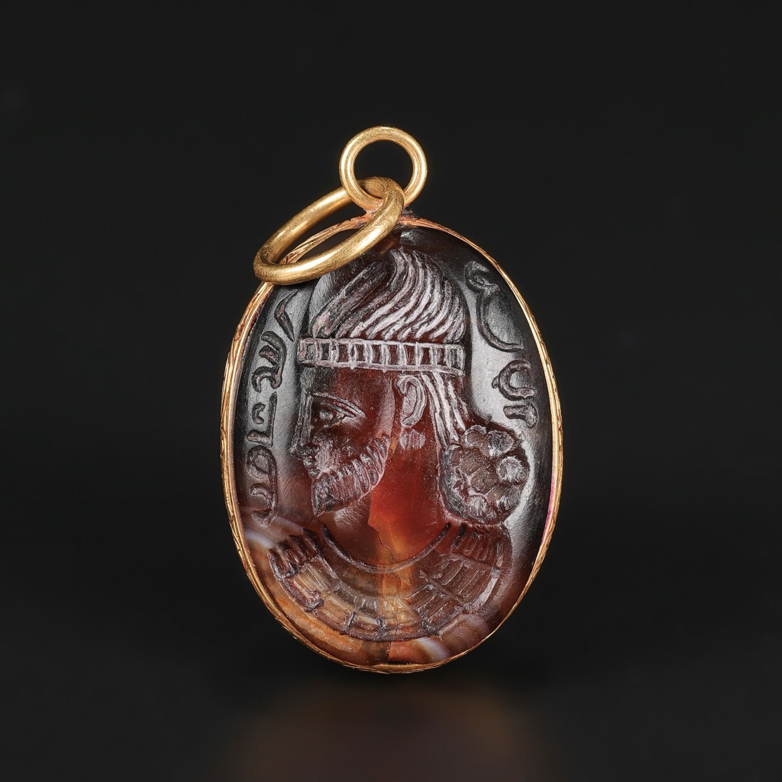 Ancient Early Sasanian Agate Intaglio Pendant Mounted in 18K Gold – 7.2g: An Early Sasanian pendant featuring a finely engraved head profile bust in agate, mounted in 18K gold. Weighing 7.2 grams. 2 x 3cm 7.2gram