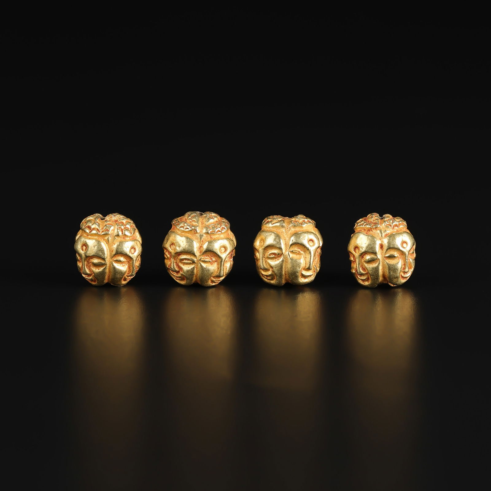Pagan Dynasty 18K Gold Four-Faced Buddha Head Pendant Beads Lot: Lot of Pagan Dynasty pendant beads crafted in 18K gold, each featuring a four-faced Buddha head motif. These finely worked pieces reflect the spiritual symbolism and goldsmithing traditions of early S
