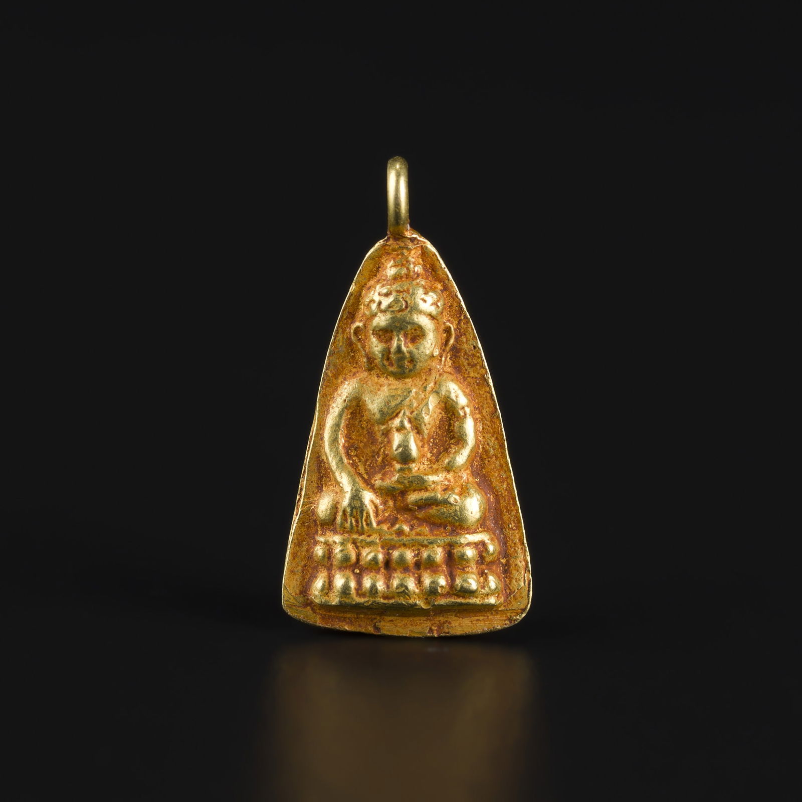 Southeast Asian Antique Buddhist Amulet 19K Gold Pendant: Antique Southeast Asian pendant crafted in 19K gold, featuring a Buddha amulet motif. Size Detail: 0.8 x 1.6cm Weight: 0.9gram