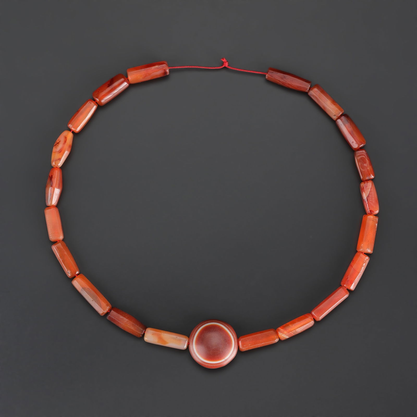 Antique Carnelian Agate Bead Necklace with Central “Magic Eye” Pendant: Antique necklace composed of carnelian agate beads, featuring a central “magic eye” pendant. Length: 21in Total Weight: 86gram