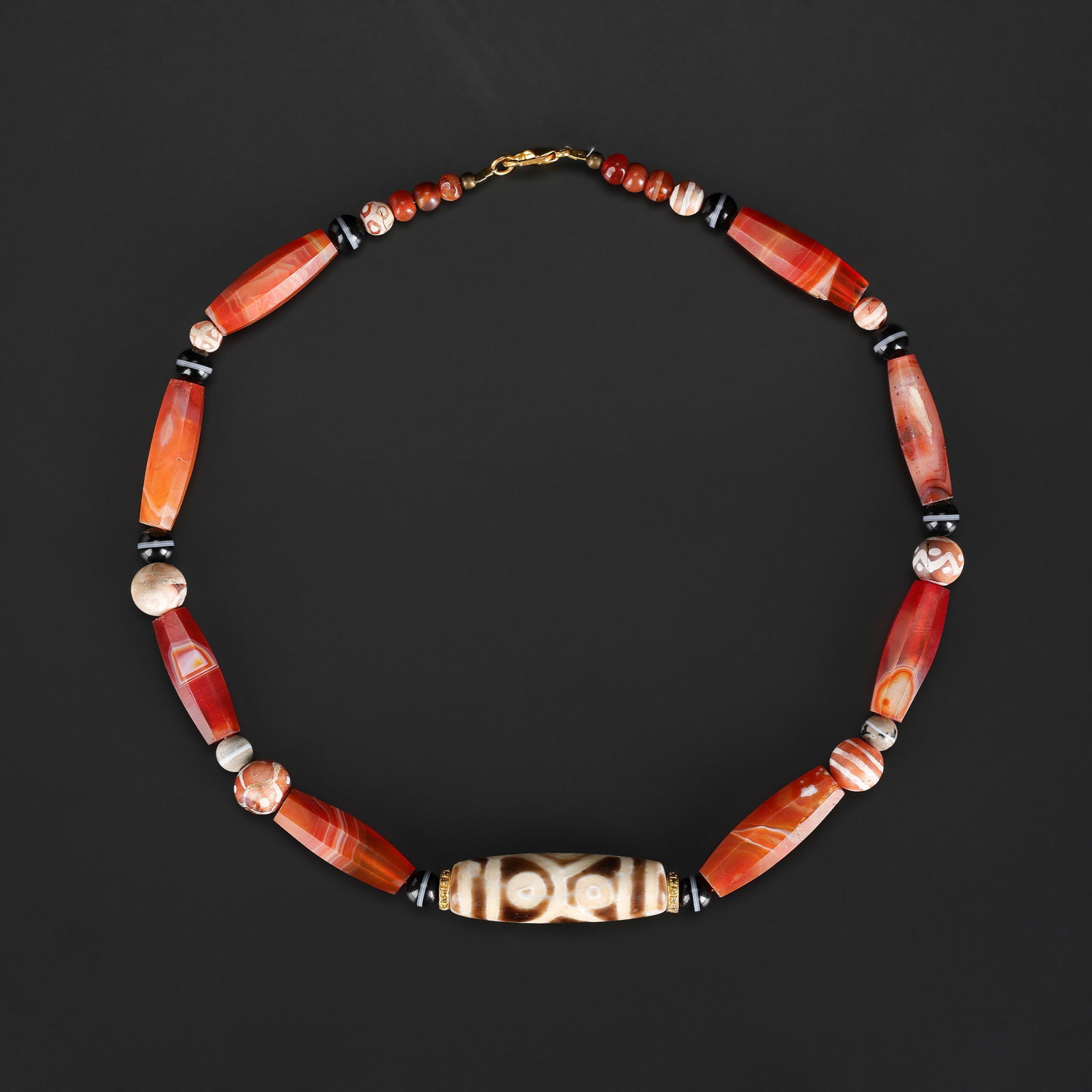 Tibetan Eye Dzi Bead String with Faceted Carnelian Beads Necklace: Tibetan necklace featuring an eye Dzi bead strung with faceted carnelian beads. Length: 20in Total Weight: 89gram