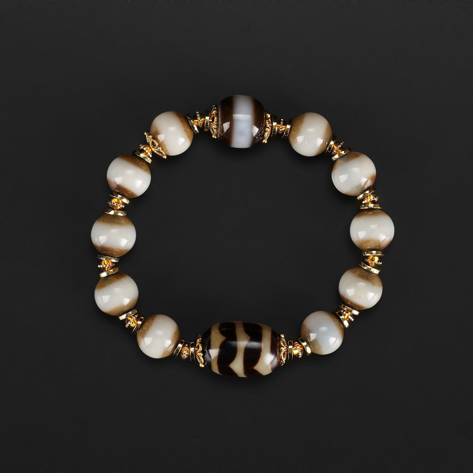 A Tibetan Agate Dzi Bead Amulet Bracelet: A bracelet composed of Tibetan agate beads, including Dzi-style amulets, strung together as a spiritual and protective ornament. Total Weight: 28gram