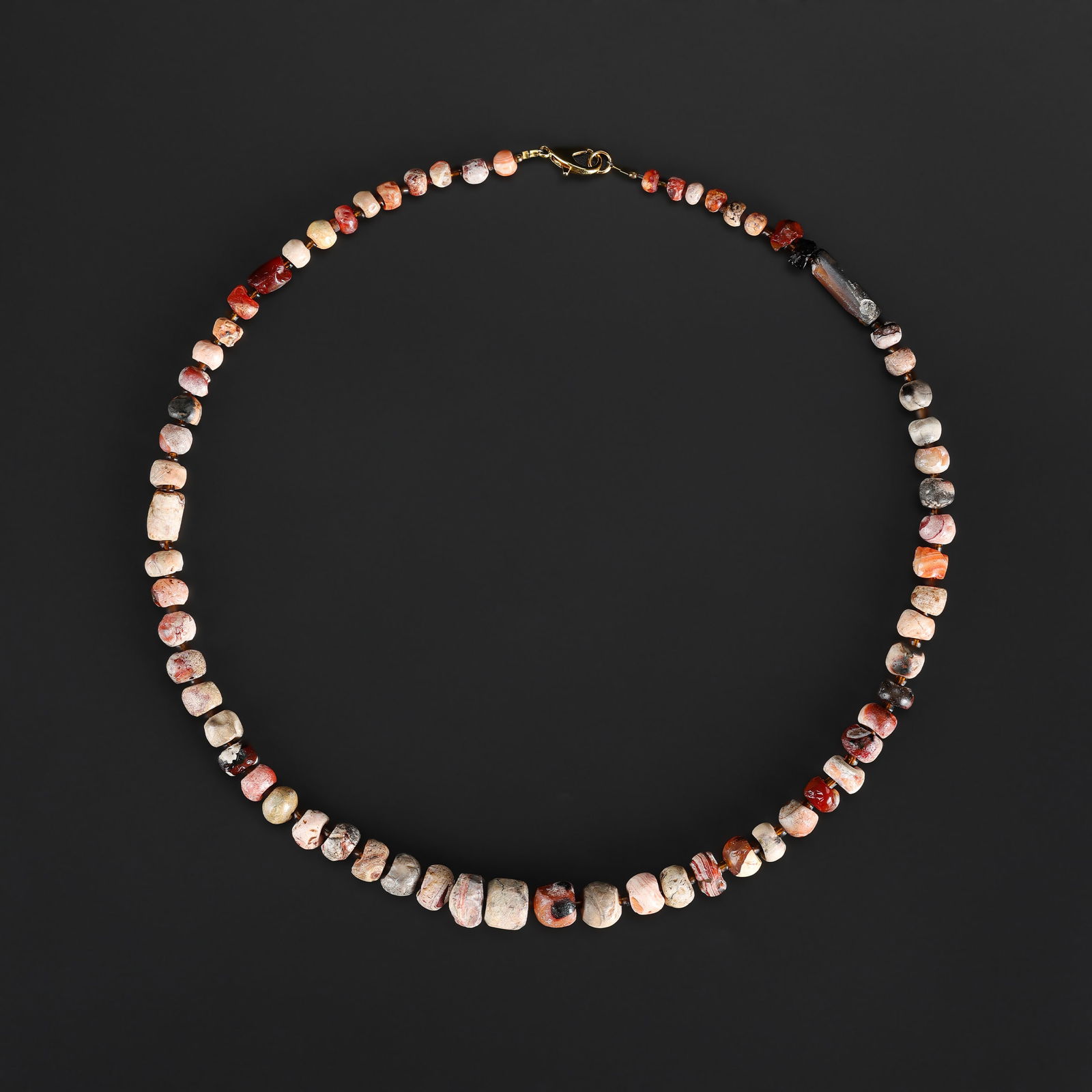 An Ancient Natural Carnelian Bead Necklace with Full Patina: A necklace composed of natural carnelian beads, displaying rich color and a full patina reflecting significant age and use. Length: 21in Total Weight: 51gram