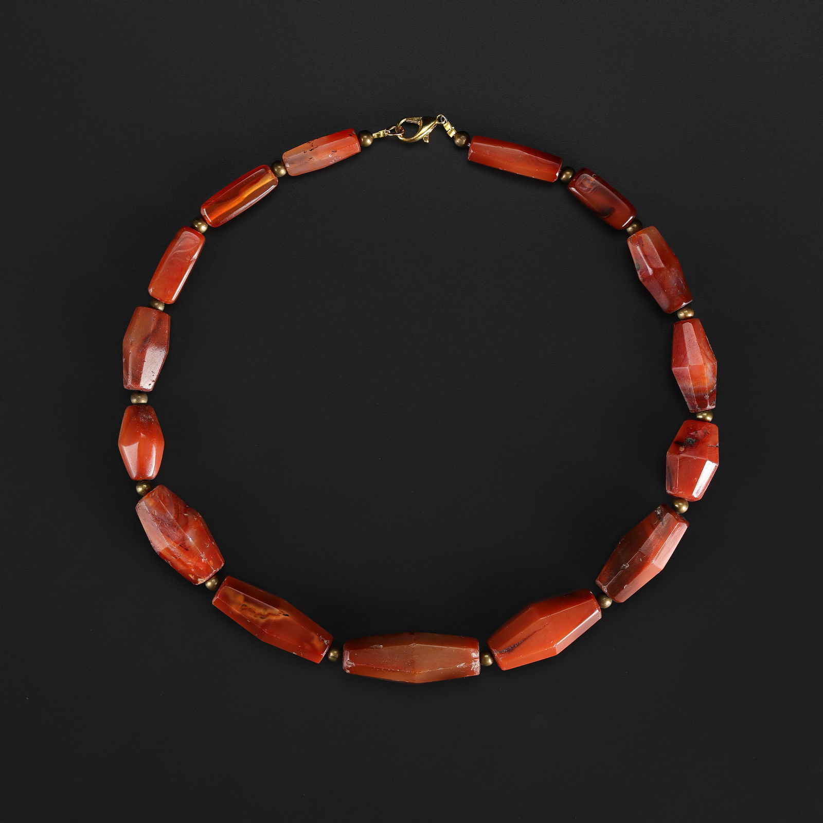 A Ming Dynasty Carnelian Faceted Bead Necklace: A necklace composed of faceted carnelian beads, dating to the Ming dynasty, exhibiting rich reddish-orange color and subtle surface wear consistent with age. Length: 20in Total Weight: 115gram