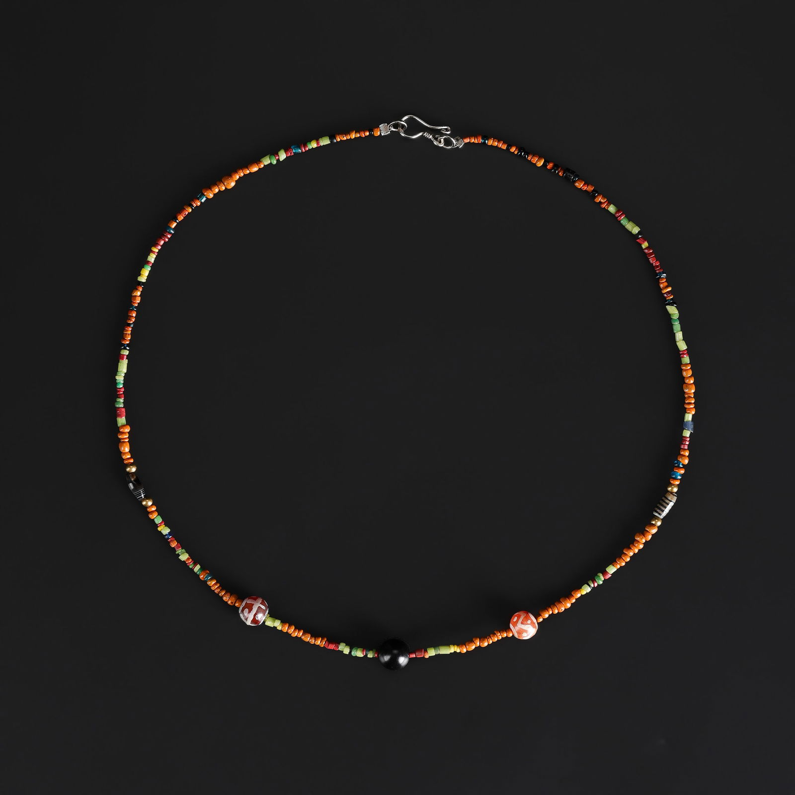 A Collection of Antique Mixed-Material Beads Necklace: A necklace comprising an assortment of antique beads in varied materials, shapes, and colors, showing natural wear and patina consistent with age. Length: 17in Total Weight: 5gram