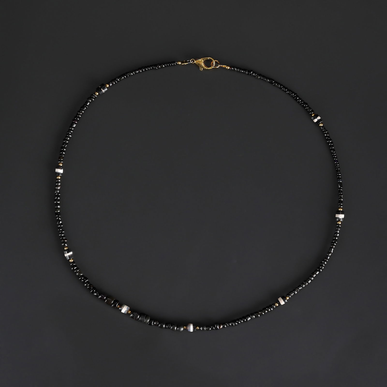 A Himalayan Chung Dzi Bead Necklace with Black Glass Spacers: A small beaded necklace featuring Himalayan Chung Dzi beads, strung with black glass spacer beads. Length: 21in Total Weight: 9gram