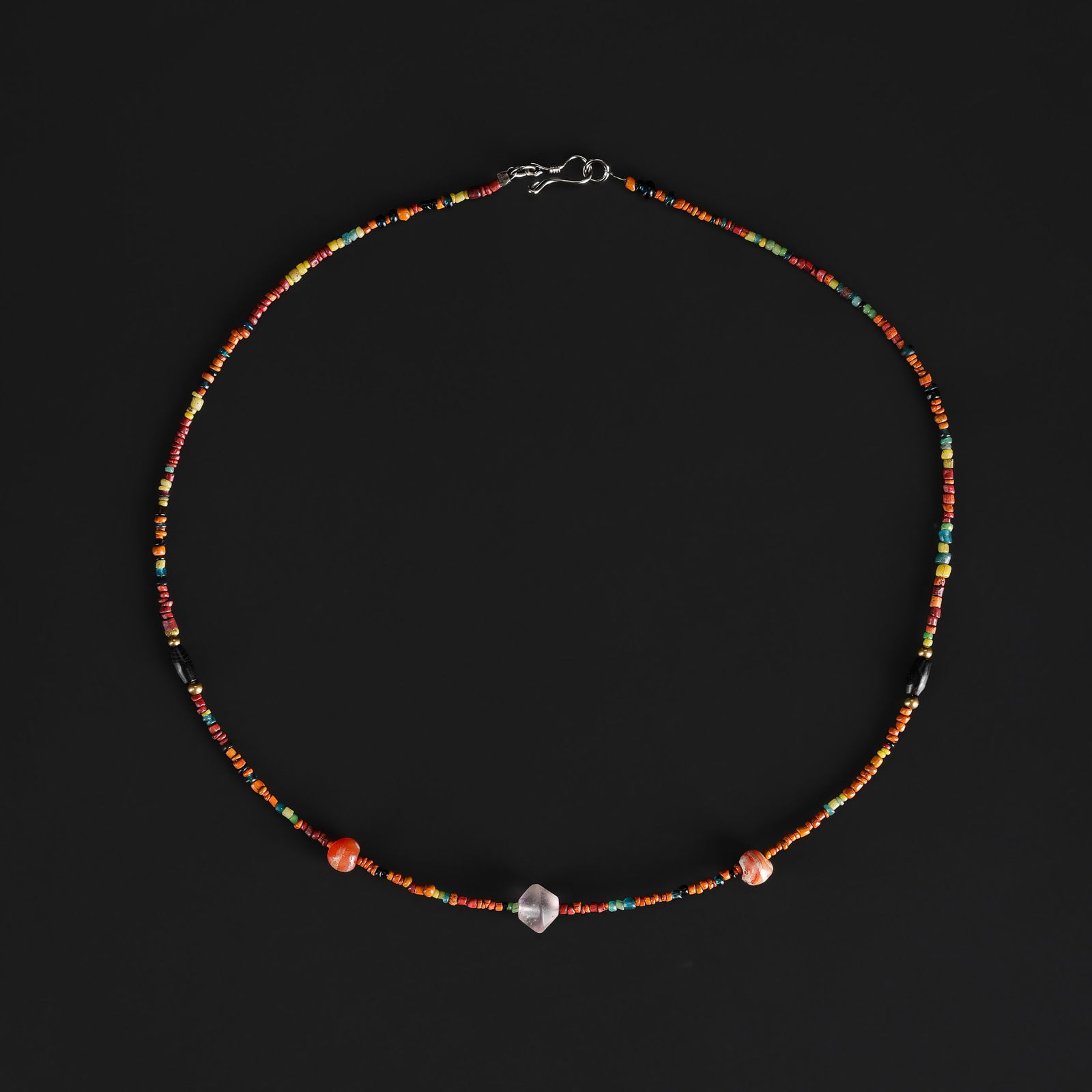 A Collection of Antique Mixed-Material Beads Necklace: A necklace comprising an assortment of antique beads in varied materials, colors, and shapes, exhibiting age-related wear and natural patina. Length: 18in Total Weight: 5gram