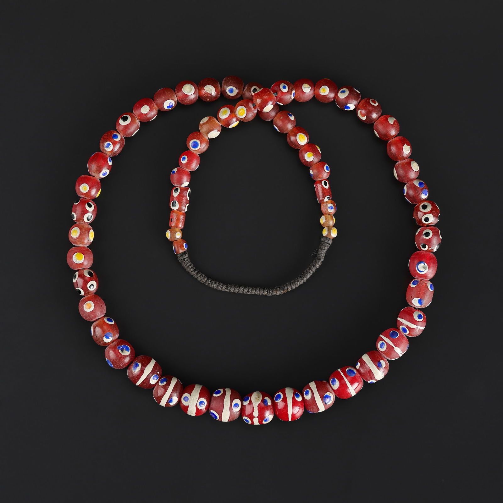 An Antique Red Venetian Flower African Trade Bead Necklace: An antique African trade bead necklace featuring red Venetian flower-shaped beads, showing natural wear and patina consistent with age. Length: 27in Total Weight: 124gram