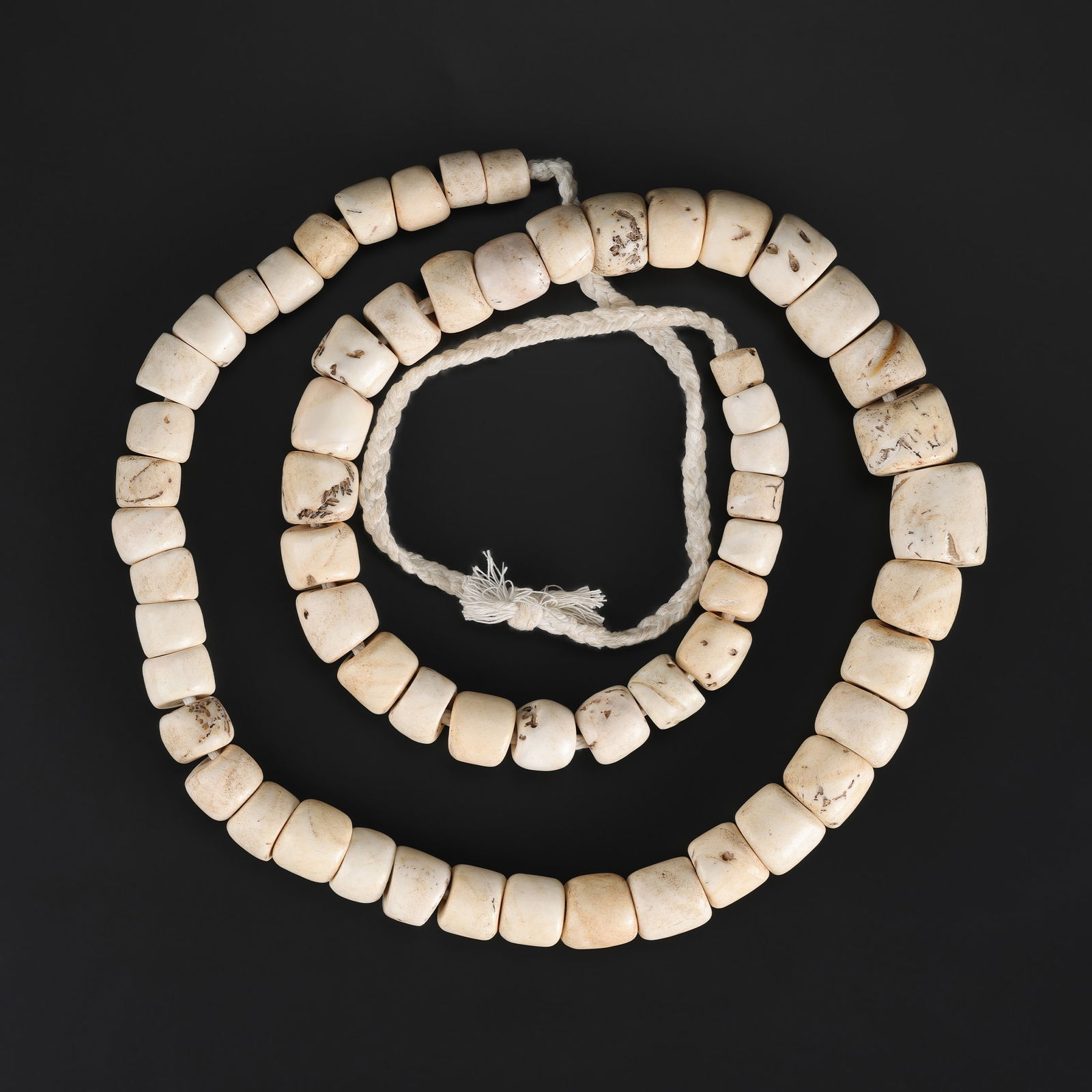 An Antique Conch Shell Bead Necklace from Nagaland: An antique necklace composed of conch shell beads from Nagaland, exhibiting natural coloration, surface wear, and age-appropriate patina. Length: 38in Total Weight: 648gram