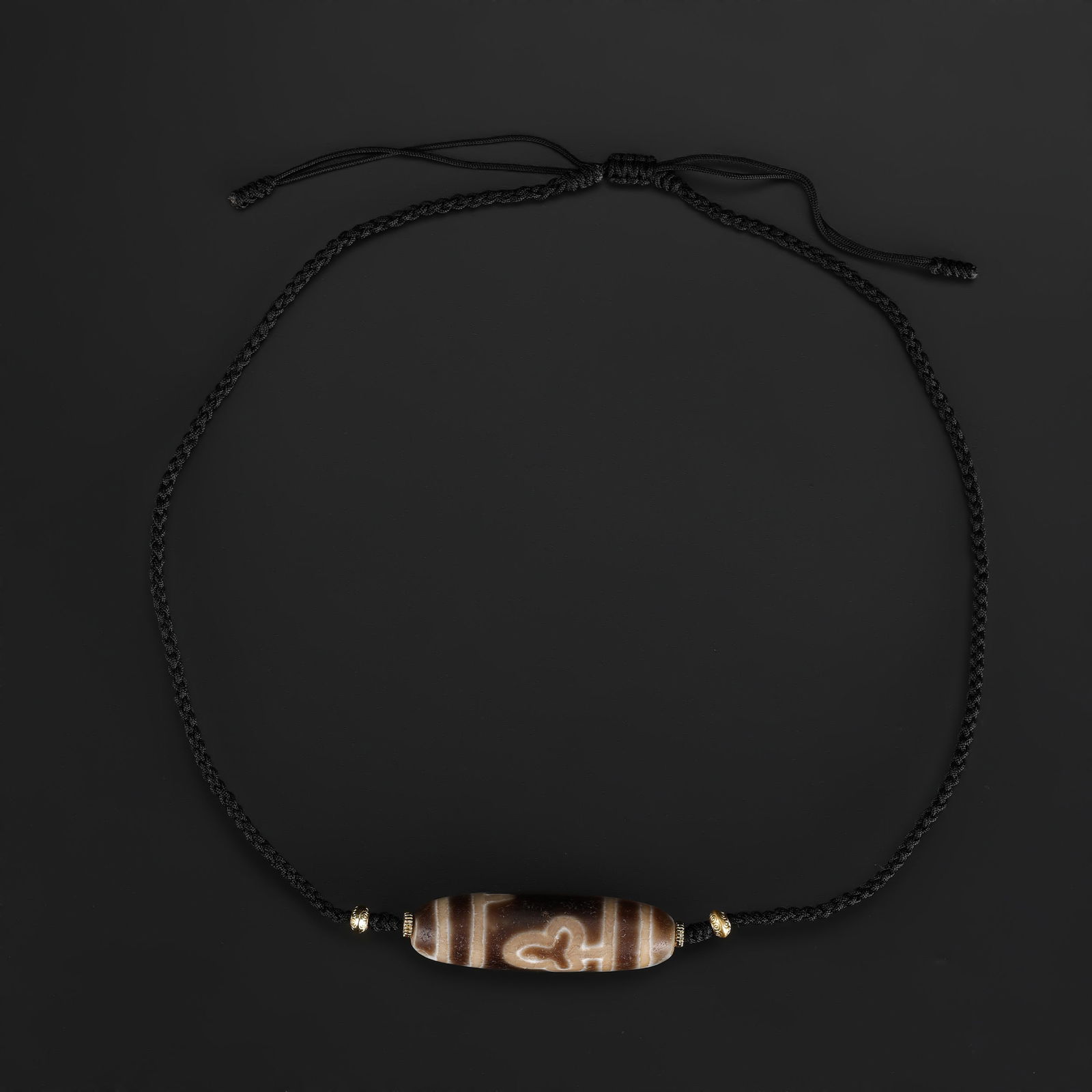 Tibetan Phum Dzi Bead Necklace with Leaf Pattern: Tibetan Phum Dzi bead featuring an intricate leaf pattern, hand-knotted on soft fabric cord to form a beautifully balanced necklace. Total Weight: 18gram