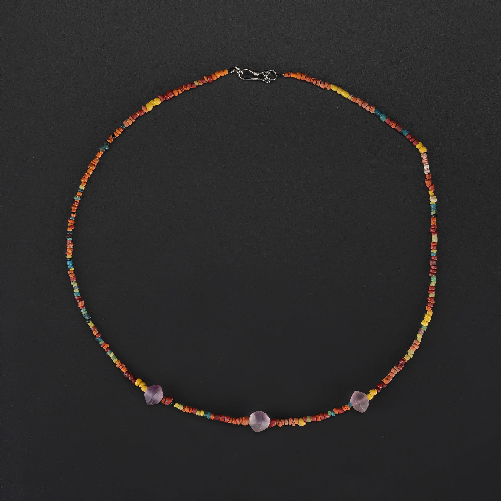 Antique Mixed-Material Necklace with Amethyst and Ancient Glass Beads: Antique necklace featuring amethyst beads combined with small ancient glass beads, strung together to create a harmonious and visually appealing design. Length: 18in Total Weight: 7gram