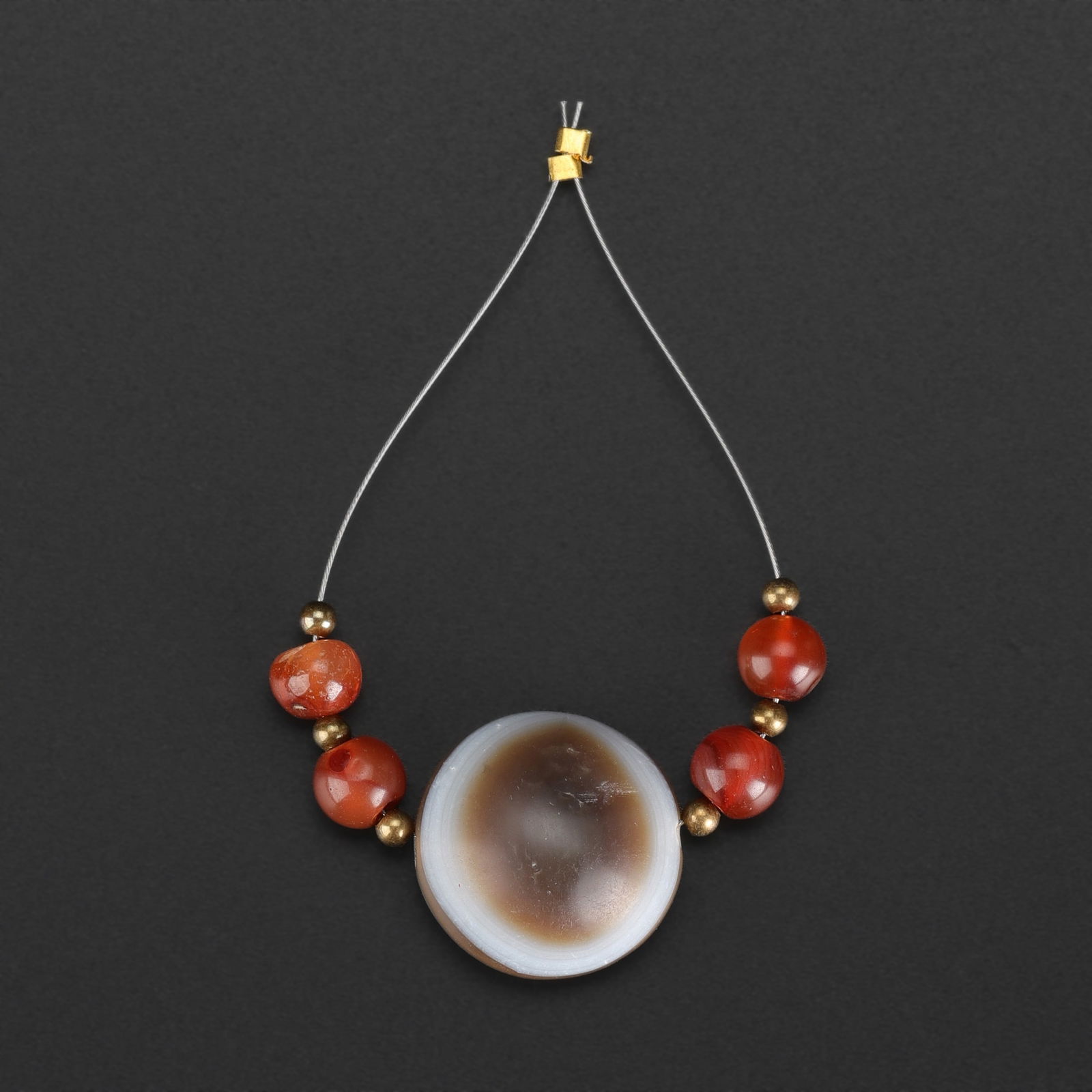 Collectible Indo-Tibetan Himalayan “Magic Eye” Lukmik Agate and Carnelian Beads: A rare collectible set of Indo-Tibetan Himalayan beads featuring a striking “Magic Eye” Lukmik bead in agate, accompanied by polished carnelian beads. Total Weight: 10gram