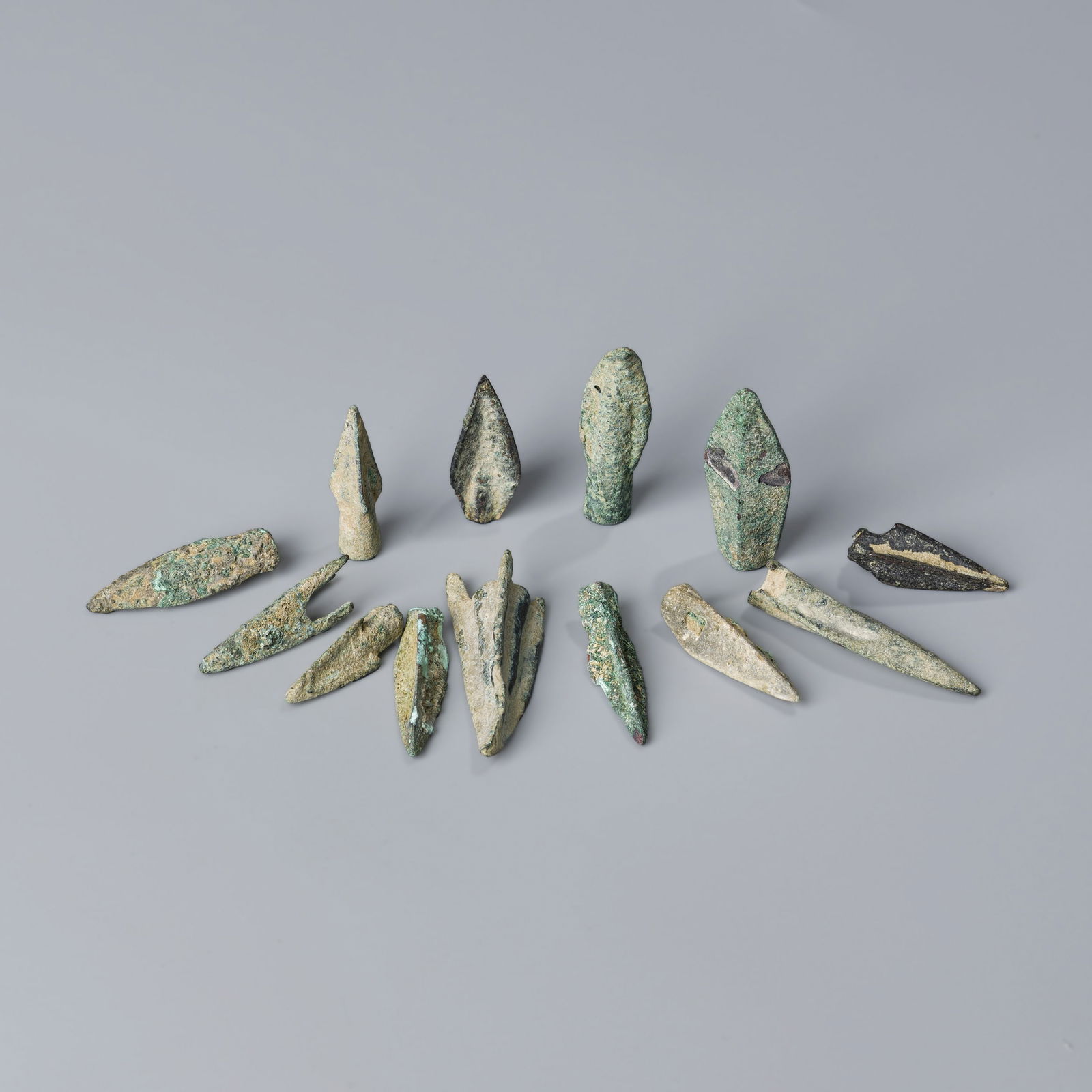 Group of 13 Ancient Bronze Arrowheads from Near Eastern Regions Roman & Greek Periods: A collection of 13 ancient bronze arrowheads originating from Near Eastern regions, dating to Roman and Greek cultural periods. Each piece shows authentic patina and historic craftsmanship typical of