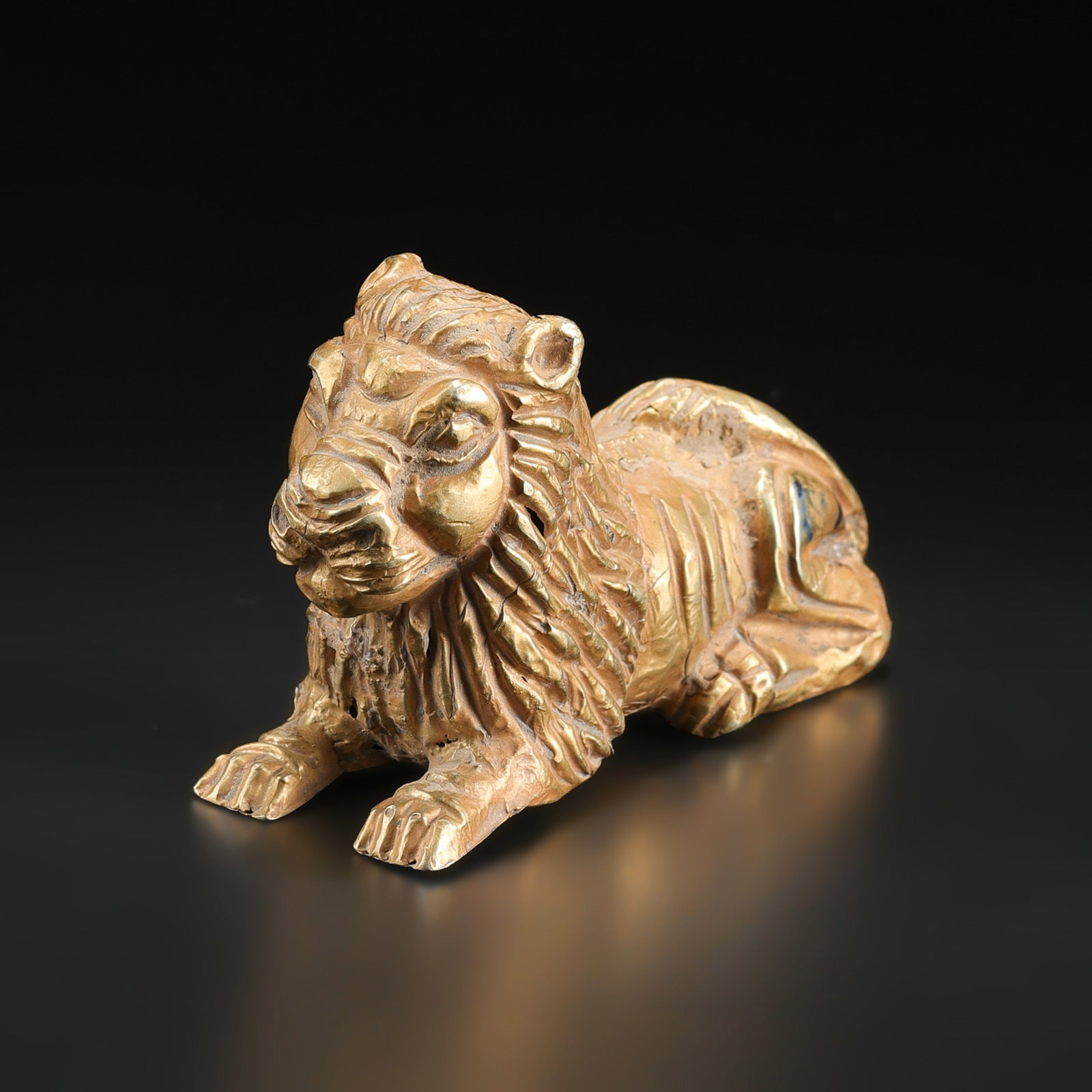 Ancient Egyptian 14K Gold Bastet Lion Statue: Ancient Egyptian Bastet lion figure crafted in 14K gold. The piece depicts the feline goddess Bastet in a detailed standing form with fine goldwork and an antique- finish. A collectible Egyptian art a