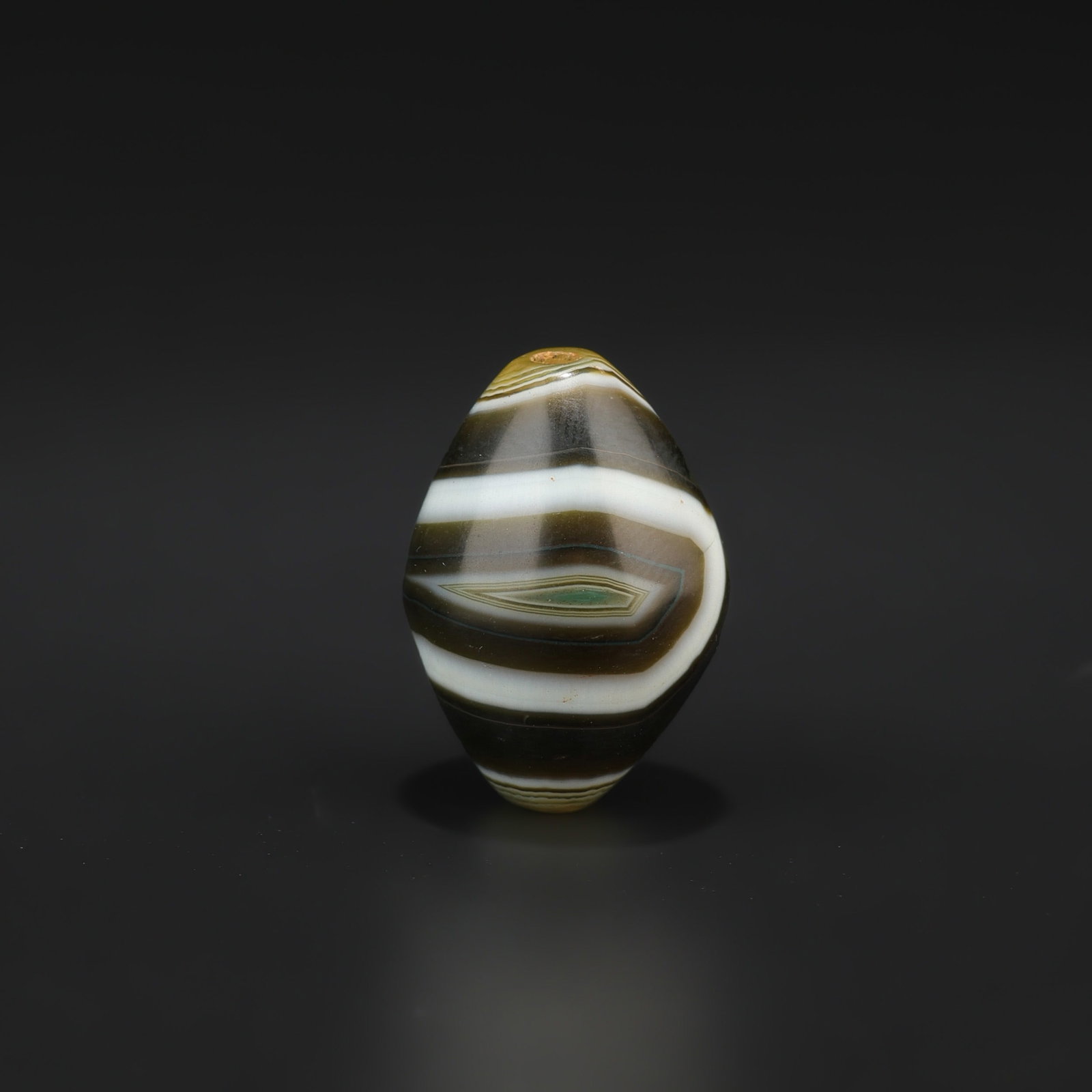 Tibetan Dzi-Style Agate Bead with Distinct Eye Motif: Tibetan Dzi-Style Agate Bead with Distinct Eye Motif featuring quality craftsmanship and collectible appeal. Suitable for display or collection. Size Detail: 1.8 x 2.6cm Weight: 10gram