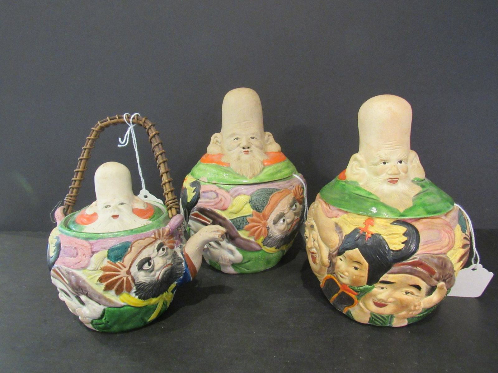 Lot of 3 Banko Japanese Gods of Good Fortune Teapot: Lot of 3 Banko Japanese Gods of Good Fortune Teapot Bowls Two bowls, head serves as knob for cover. One teapot (5.75'' x 4'' x 5.25''), head serves as knob for cover, bamboo handle. Both bowls and tea