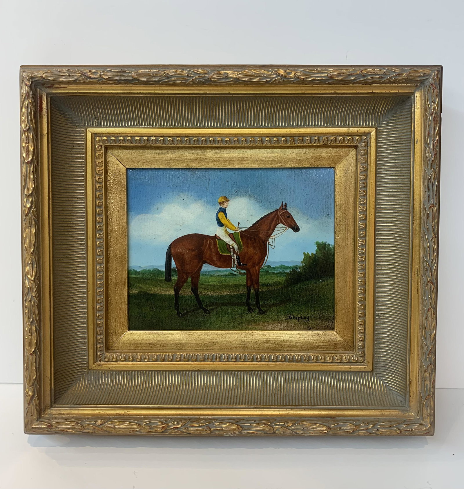 Contemporary Horse Jockey Oil Painting Signed Shipley: Contemporary Horse Jockey Oil Painting Signed Shipley. Horse jockey wearing blue, yellow, and white uniform. Framed. Painting measurement (without frame) approximately 10" x 8.25".