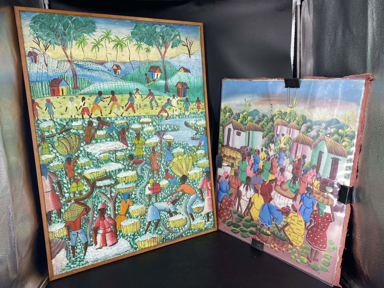 2 Original Haitian Folk Art Signed MJ Roland Painting: Two vintage original haitian oil on canvas painting, one signed by MJ Roland. One is framed and the other is not. Paintings measure at approx. 31.75" x 23.5" and 24" x 20". One frame measures at appro