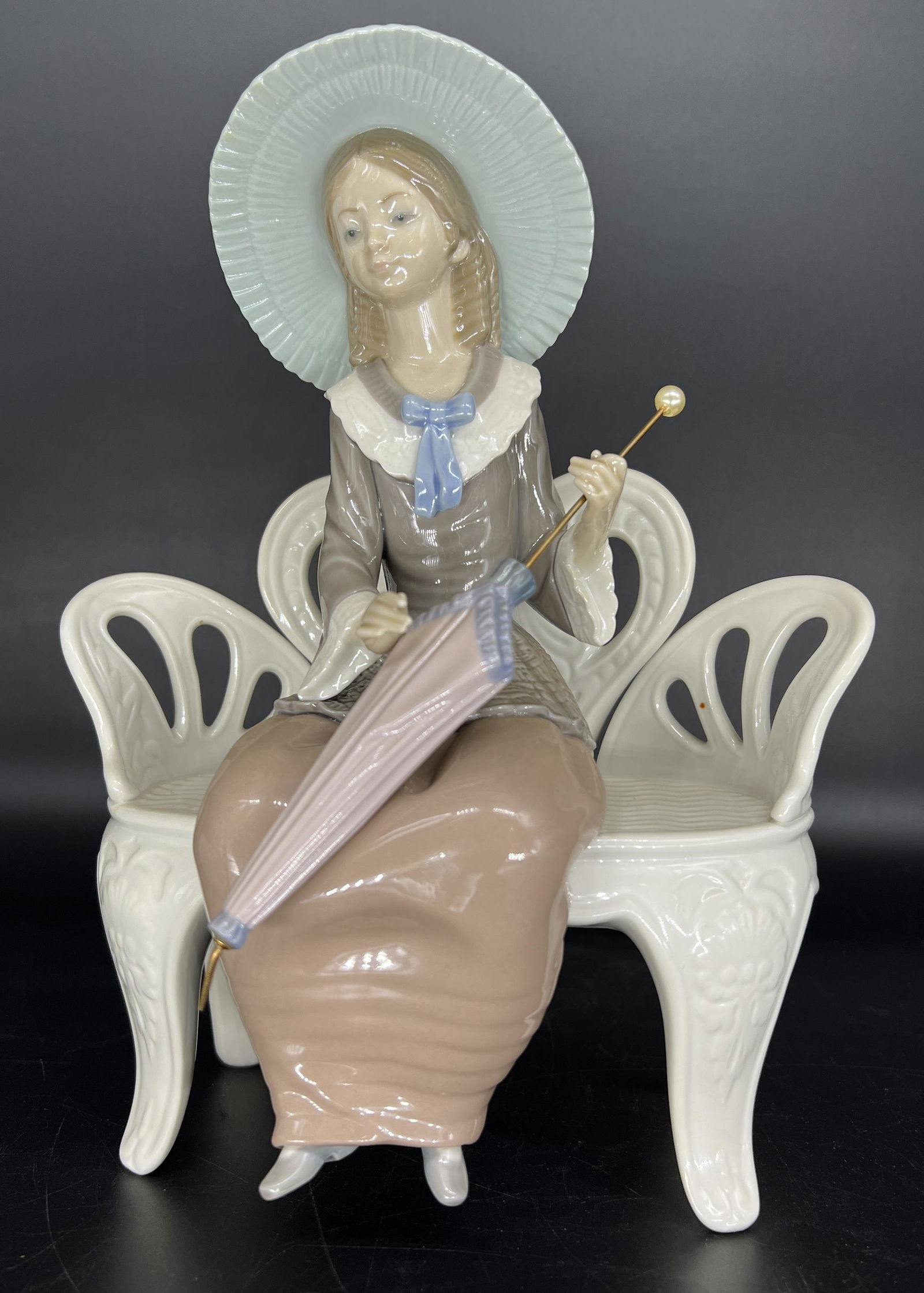 Antique Lladro Spain 'Waiting in The Park' #1374 Porcelain Figurine: Vintage Lladro Spain 'Waiting In The Park' #1374 Porcelain Figurine. Figurine depicts a young lady carrying an umbrella and sitting on a park bench. No chips or cracks noticed. Signed on bottom.