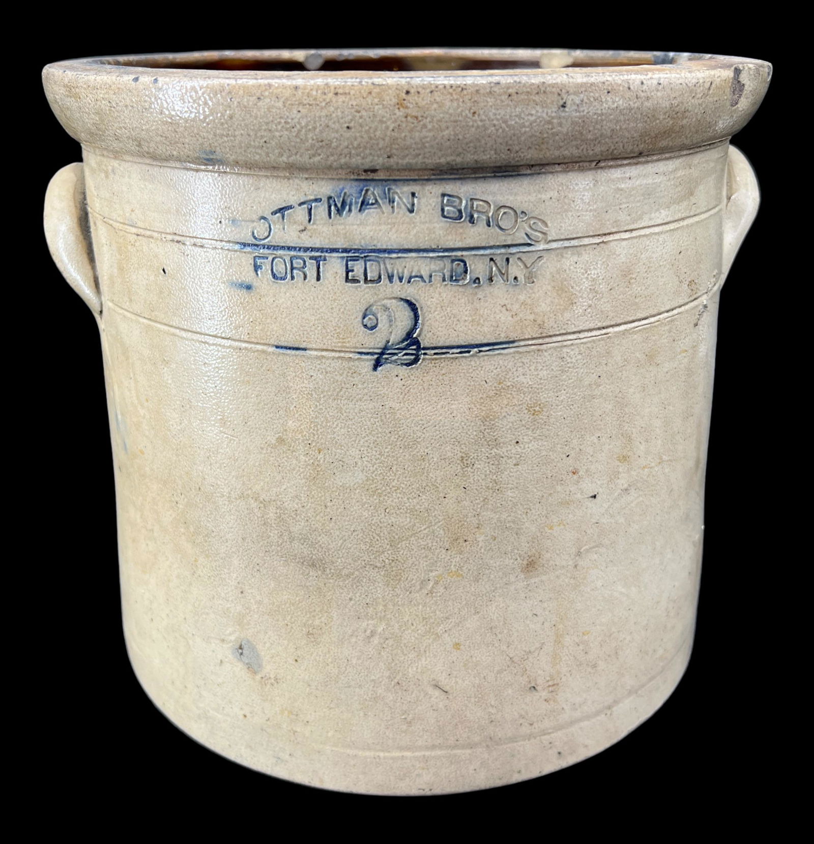 Antique Primitive 2-Gallon Stoneware Salt Glaze Cobalt Blue Stoneware Crock: Antique primitive 2-gallon stonware salt crock with elephant ear handles and cobalt blue stamped "Ottman Bro's Fort Edward, NY." Size: 9" x 10".