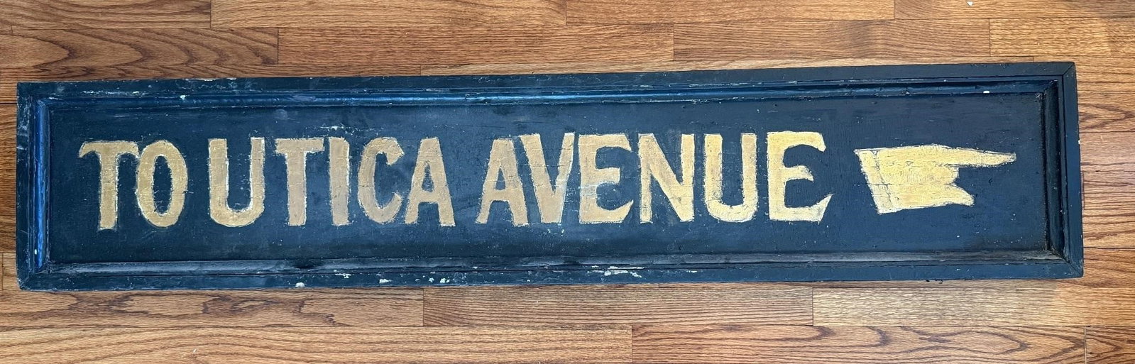 Antique Hand Painted 'To Utica Ave' Wooden Sign: There is standard age-related wear to this sign. Approx. Dimensions (in): 60 x 12 x 2.5.