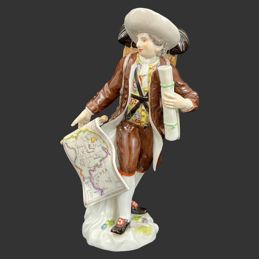 Meissen 'Map Seller' Porcelain Figurine: Cross-Swords Meissen mark on the bottom. Peter Reinicke Design. 243L. 73099. This figurine depicts a man selling maps. Approx. Dimensions (in): 6.5 x 4 x 2.