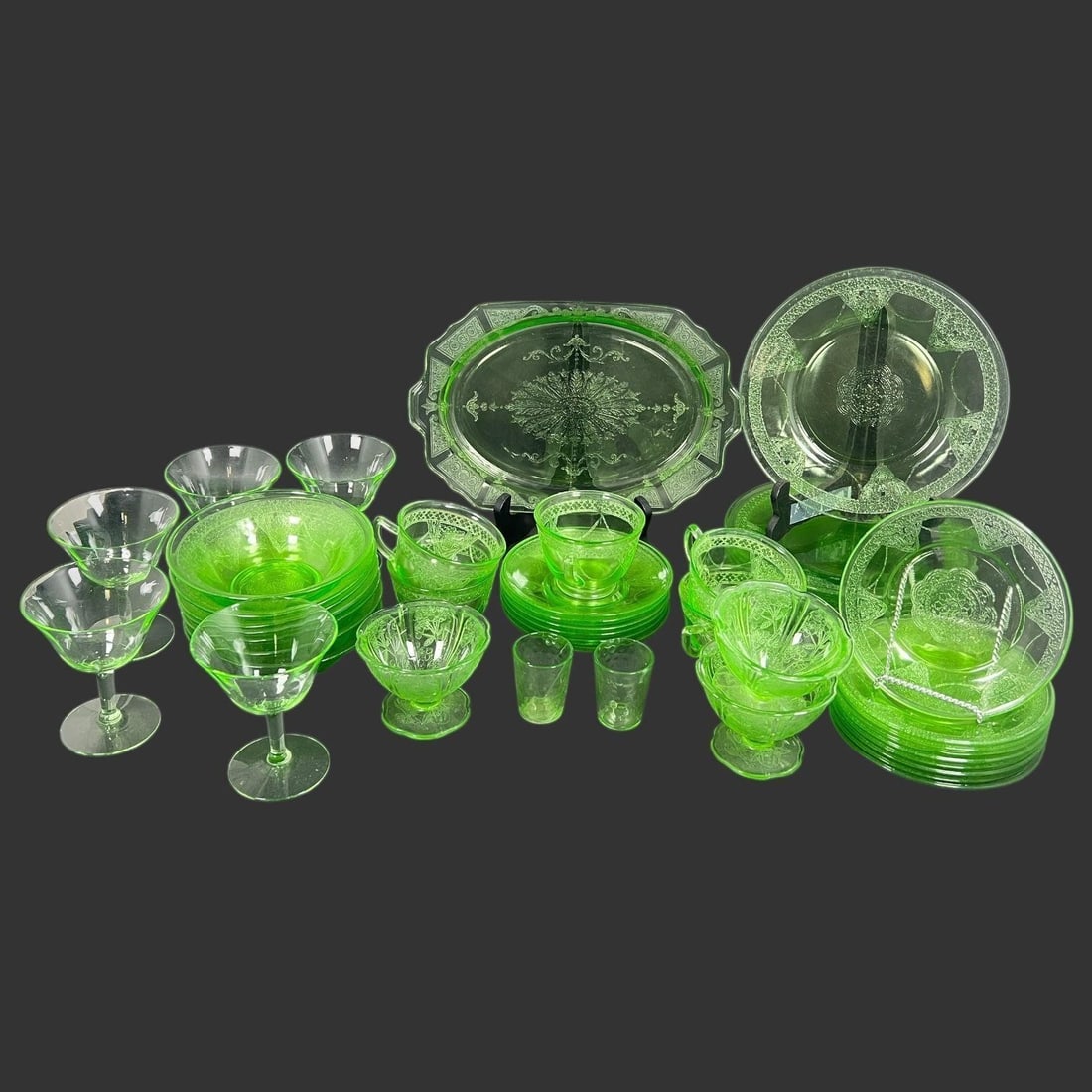 Vintage Lot of 46 Pieces Uranium Glass: Vintage Lot of 46 Pieces Uranium Glass. (8) Big Plates, (9) Small Plates, (3) Footed Bowl, (5) Cup, (6) Saucer, (2) Small Goblets, (7) Bowls, (5) Wine Glasses, (1) Serving Tray. One big, small plate,
