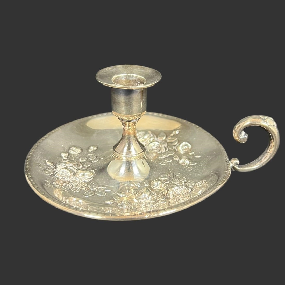 Tiffany & Co Art Nouveau Floral Candle Holder: Tiffany & Co Art Nouveau Floral Candle Holder. It boasts a broad, shallow dish base adorned with intricate floral relief decorations, characteristic of Tiffany's fine silver-plated craftsmanship. grac