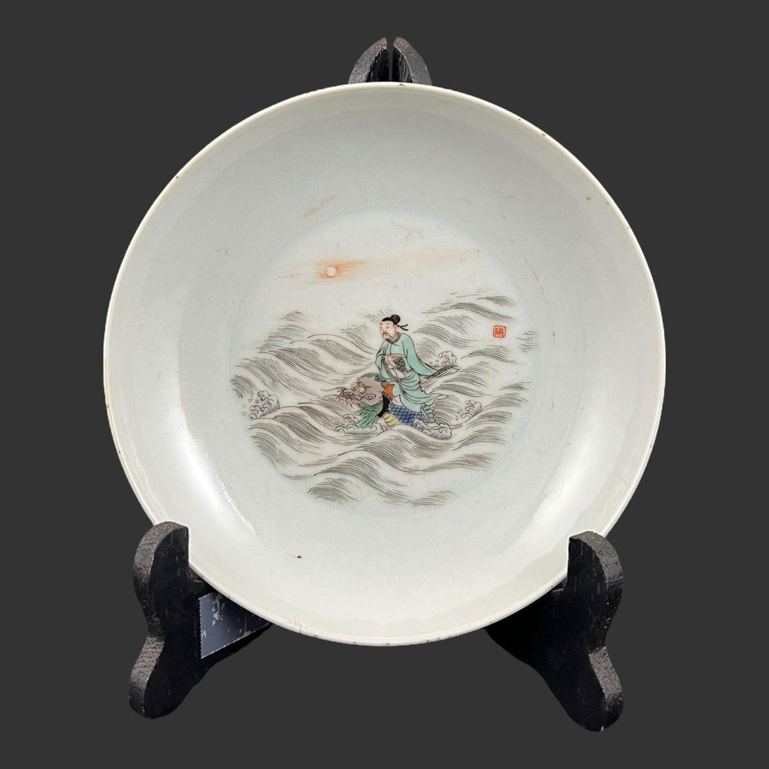 Qing Dynasty Chinese Famille Rose Porcelain Plate: Qing Dynasty Chinese Famille Rose Porcelain Plate. The central motif showcases figures amidst dynamically depicted waves with a sun in the background, a common theme in Chinese art that often relates 