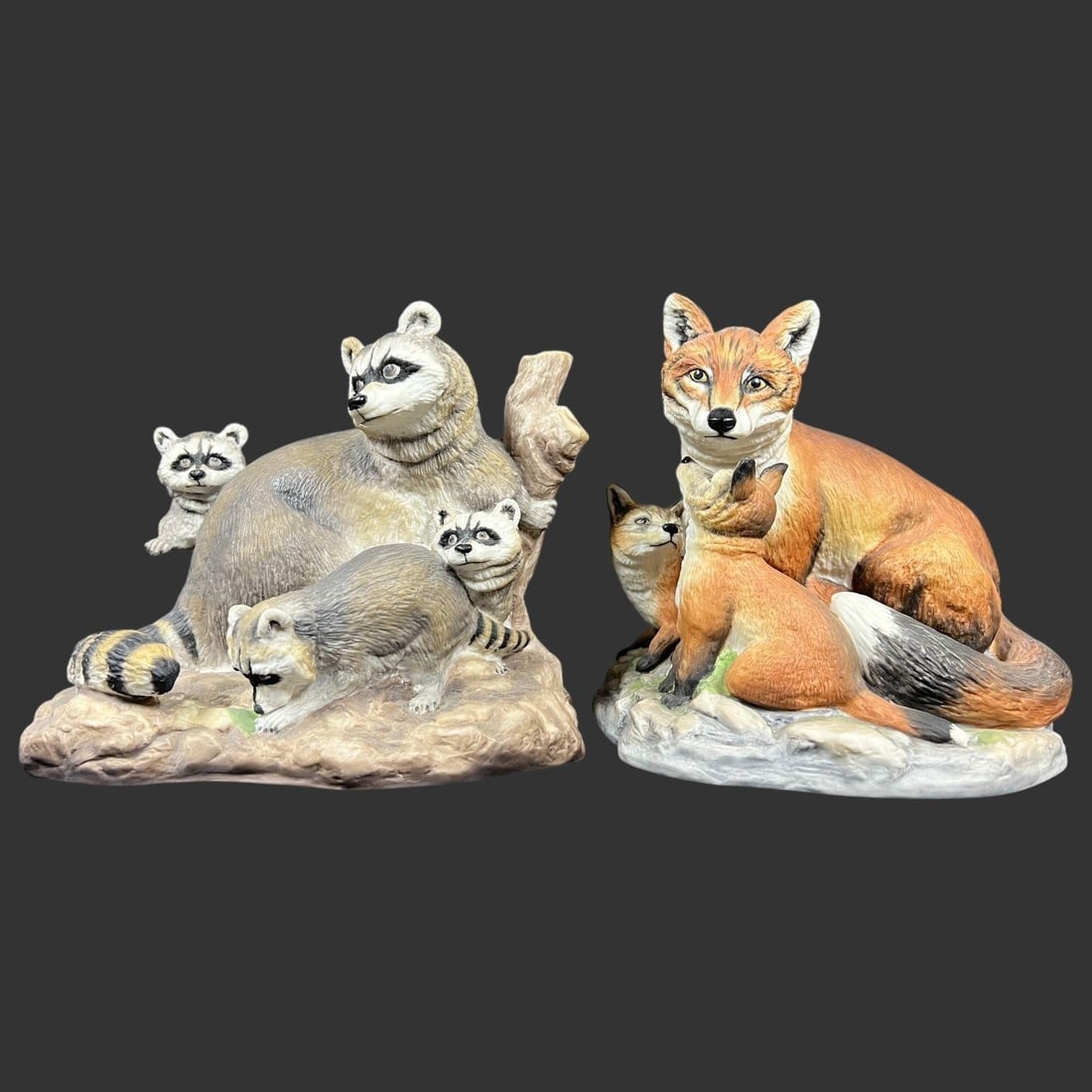 Lot of 2 Boehm Porcelain Raccoons Foxes Figurines: The piece on the left, identified as "BOEHM RACCOONS WITH CUBS" (Hallmark: 20120), was issued in 1984 and closed by 1987. The piece on the right is identified as "BOEHM PORCELAIN FOX W/KITS" (Hallmark