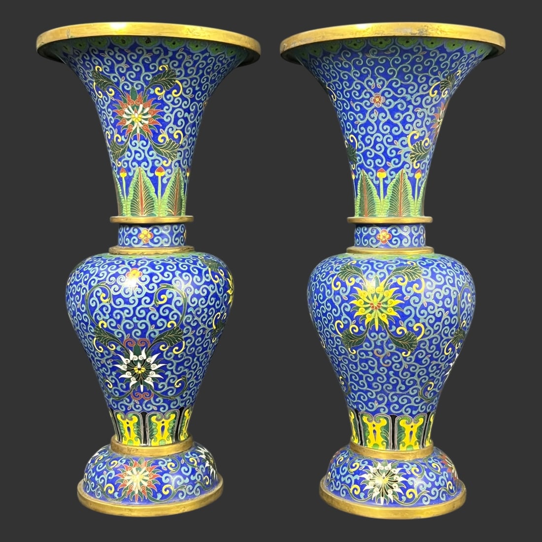 Tall Chinese Cloisonné Enamel Vases, Pair: Pair of tall Chinese cloisonné enamel vases of trumpet-neck form, decorated in a rich cobalt-blue ground filled with scrolling lotus and floral medallions, accented with yellow, green, red, and white