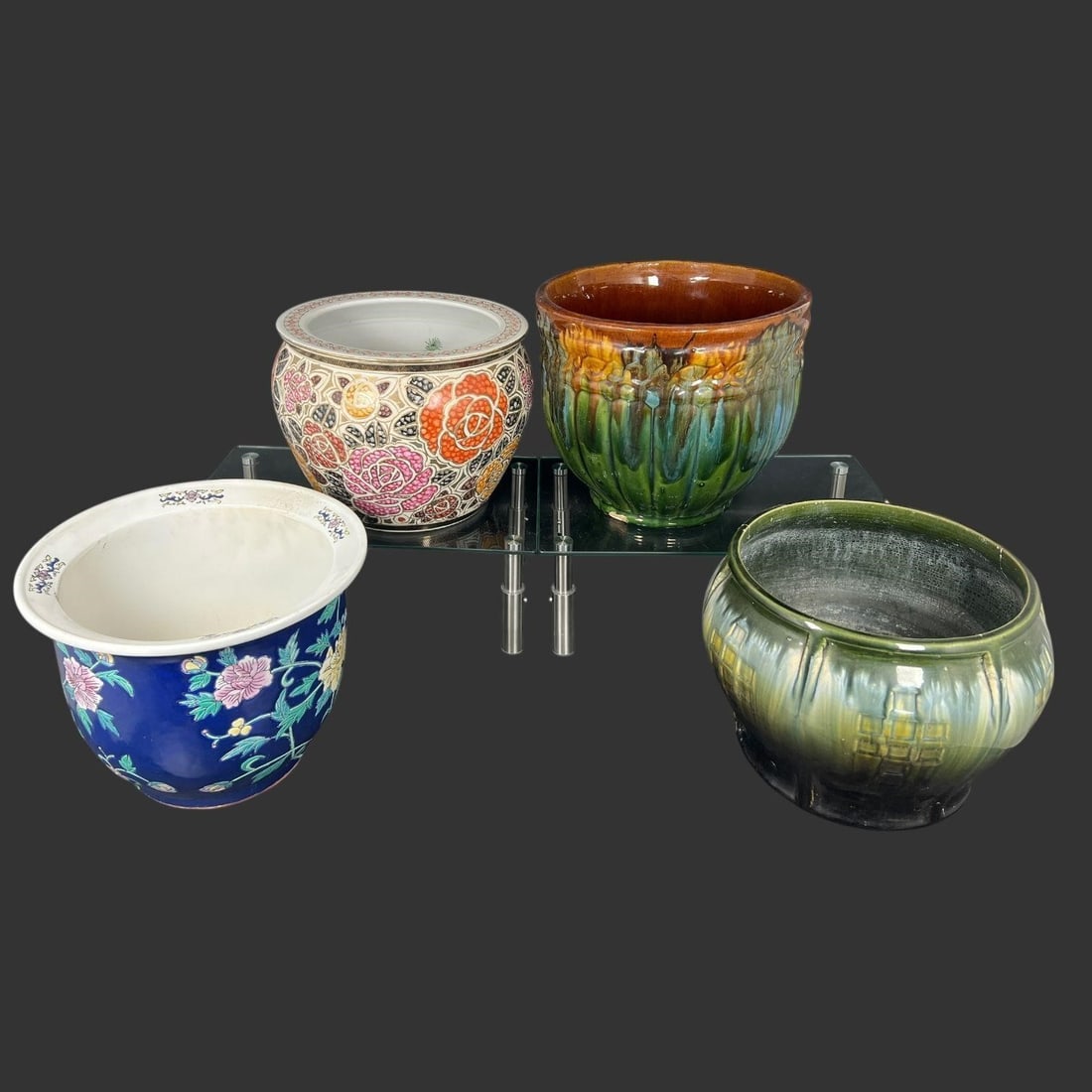 Four Decorative Ceramic & Pottery Planters: Group of four decorative planters including two Chinese porcelain examples with floral decoration and two glazed art pottery planters in green, yellow, and brown tones, featuring molded and ribbed for