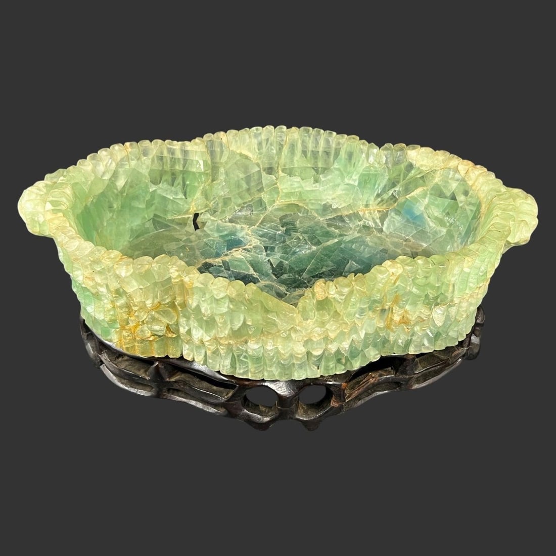 Chinese Green Quartz Bowl w/ Pierced Wood Stand: This striking carved bowl appears to be fashioned from translucent green quartz, displaying layered tonal variations ranging from pale apple green to deeper blue-green hues. The stone has been carved