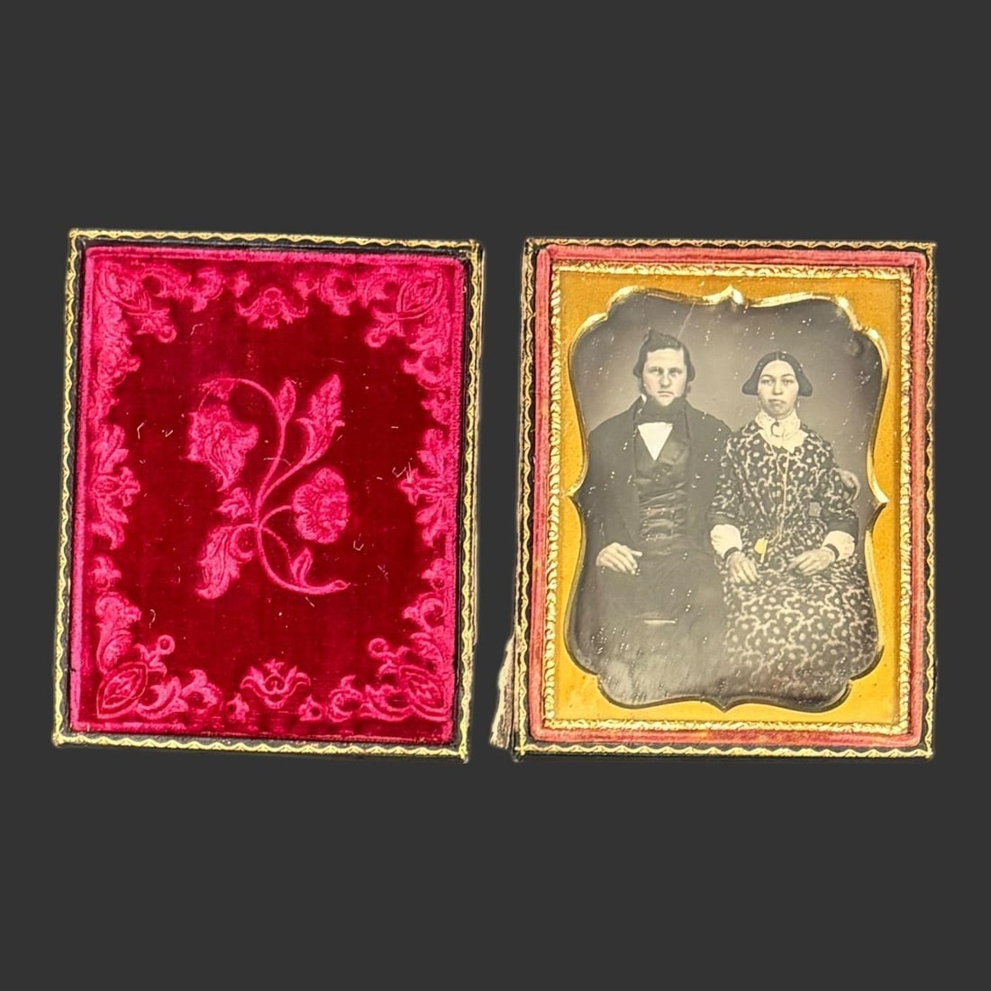 Mid-19th C. Cased Daguerreotype Portrait Couple: Mid-19th century American cased photo portrait depicting a formally dressed seated couple, presented in its original embossed leather case with floral motif and gilt highlights. The image shows period