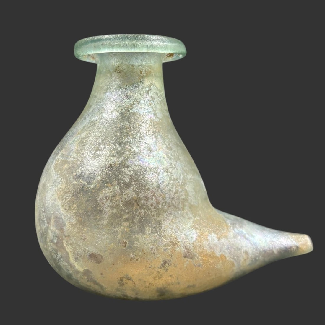 Ancient Roman Glass Baby Feeder with Side Spout: This ancient glass vessel is a Roman-period baby feeder, featuring a globular body, flared rim, and elongated tapered side spout designed for feeding infants, dating approximately to the 1st-3rd centu