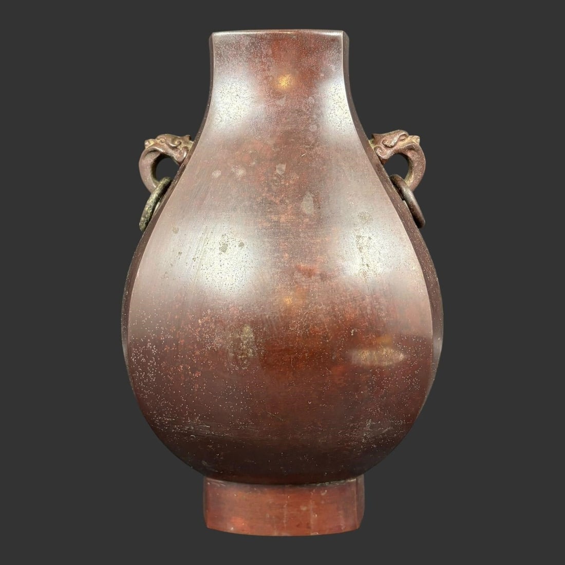 Chinese Bronze Hu Form Vase Beast Mask Handles: Antique Chinese bronze vase of classic hu form, featuring a faceted, pear-shaped body rising from a stepped foot to a squared rim. The shoulders are applied with finely cast beast mask (taotie) handle