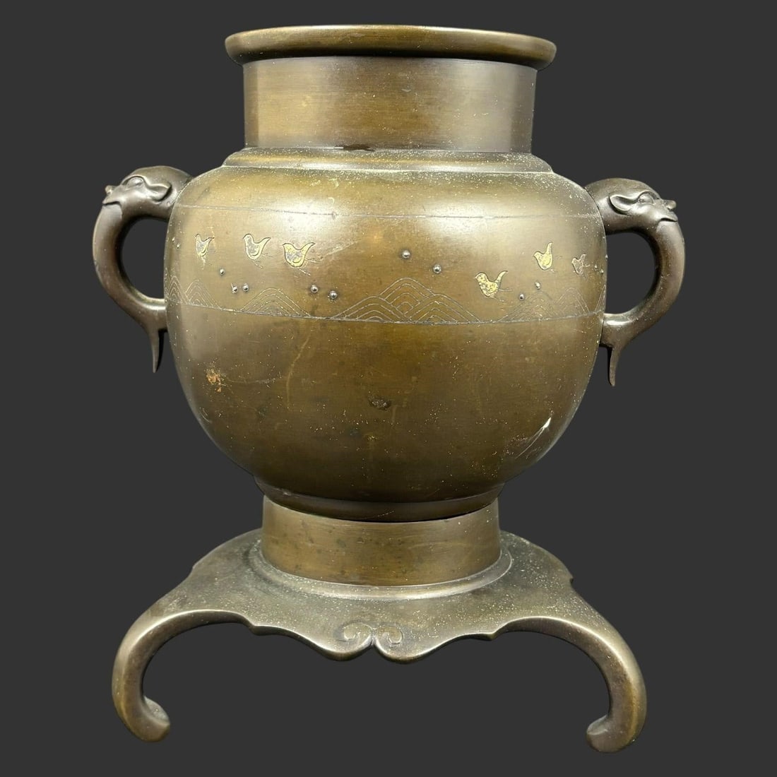 Antique Chinese Bronze Urn w/ Elephant Handles: Antique Chinese bronze urn of classical form, raised on an integrated tripod-style base with scrolled feet and featuring two finely cast elephant-head handles at the shoulders. The body is decorated w