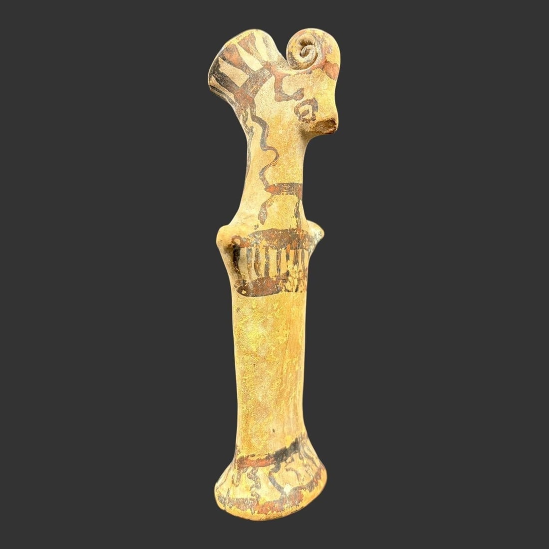 Pre-Columbian Style Pottery Ram Head Figurine: Handcrafted pottery figurine in a Pre-Columbian style, featuring a sculptural ram's head with curled horns and an elongated cylindrical body. The surface is decorated with earthy ochre slip and painte