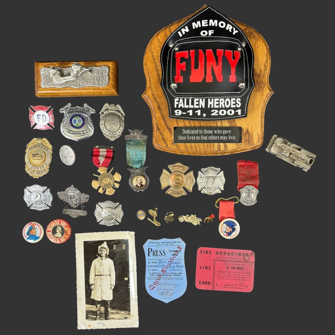 Firefighter Firemen Memorabilia Lot: Collection of firefighter memorabilia including an FDNY “In Memory of Fallen Heroes 9-11-2001” plaque mounted on an oak shield, along with a group of vintage and