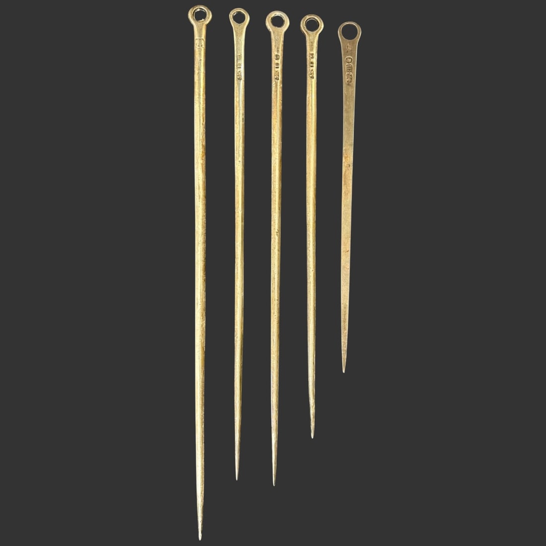 Lot of Sterling Silver English Georgian Meat Skewers: Offered here is a set of five antique sterling silver skewers each featuring a long, slender shaft with a pointed end and a circular ring handle for easy grip. The pieces display visible hallmark