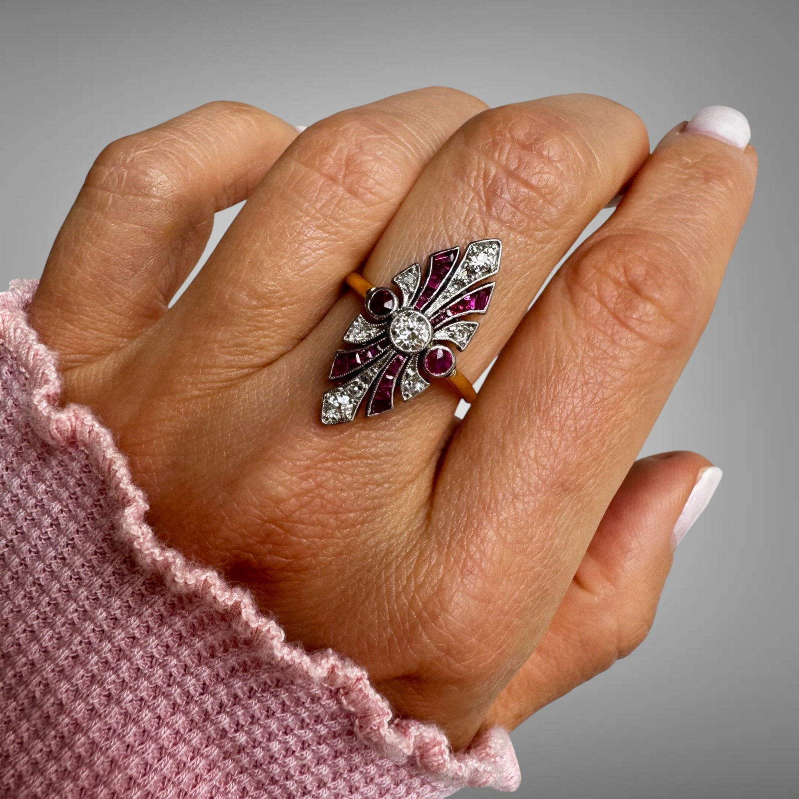 Vintage Art Deco 18K Gold Ruby & Diamond Navette Ring: A striking vintage Art Deco ring crafted in 18K gold, featuring a dynamic geometric design centered with a sparkling old-cut diamond. The elegant composition is accented by vivid calibr