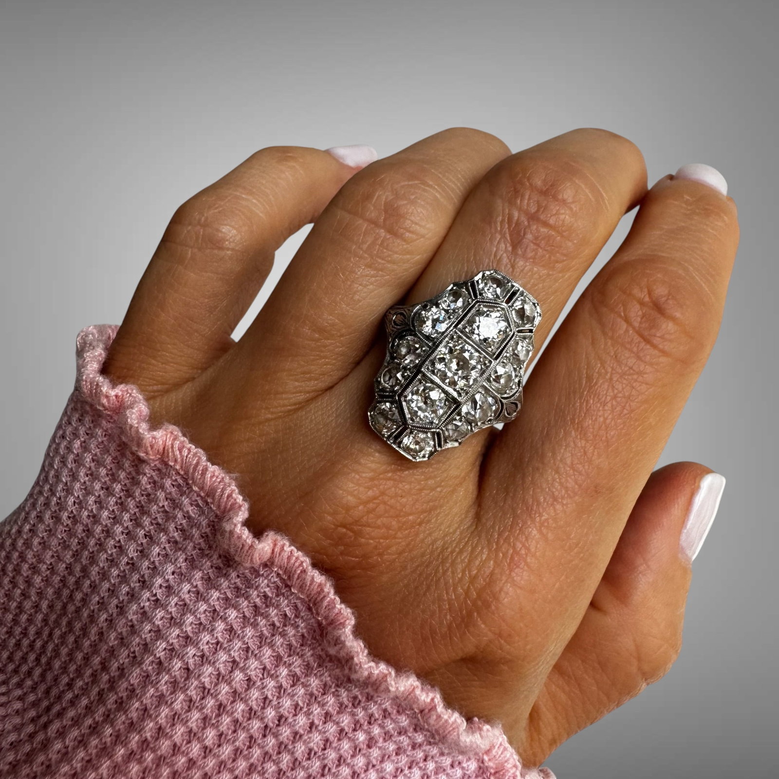 Vintage Art Deco Platinum Diamond Ring: An elegant vintage Art Deco ring crafted in platinum, showcasing exquisite geometric detailing and old European cut diamonds. The elongated octagonal design features a dazzling center arrangement fram